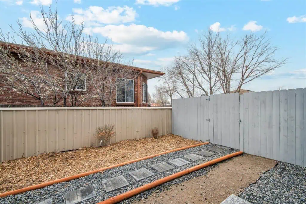 Backyard with stone pathway and wooden fence