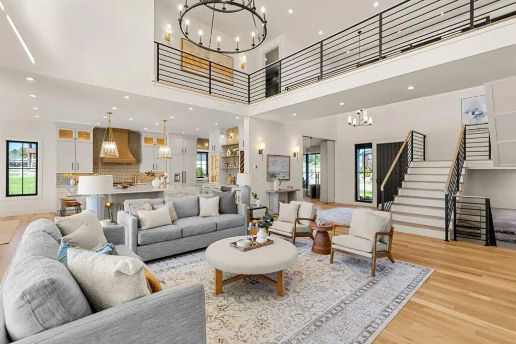 Spacious modern living room with kitchen and stairs.