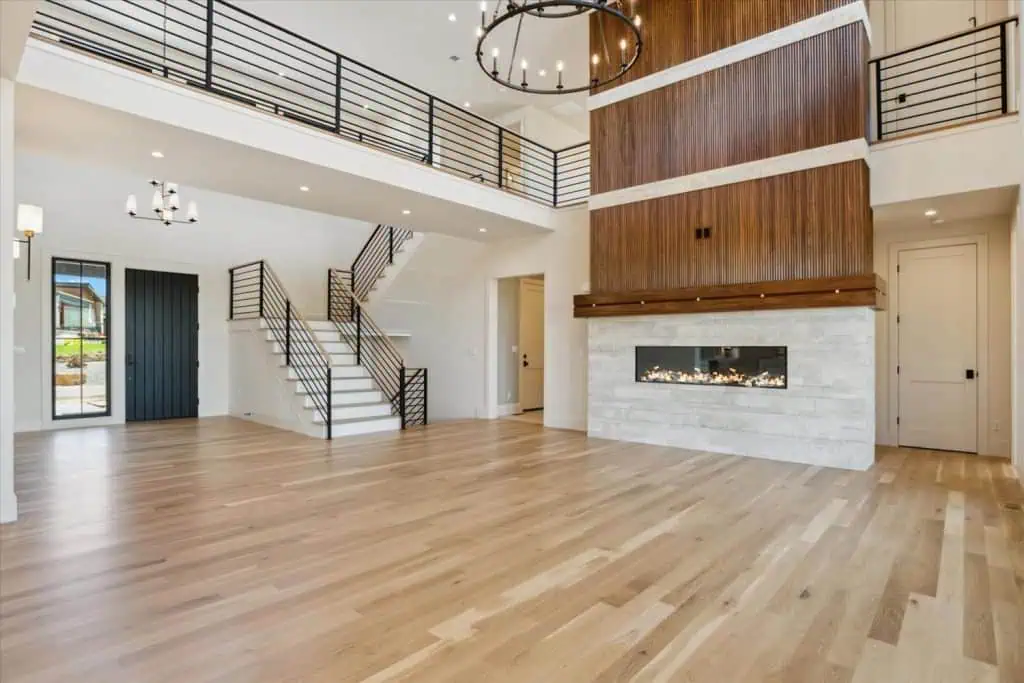 Spacious modern living room with fireplace and staircase.