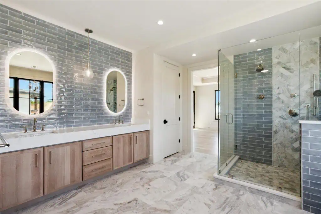 Modern bathroom with glass shower and double vanity.