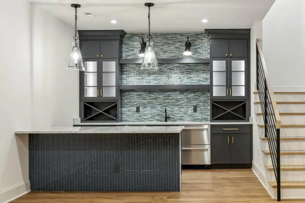 Modern kitchen with dark cabinets and mosaic backsplash.