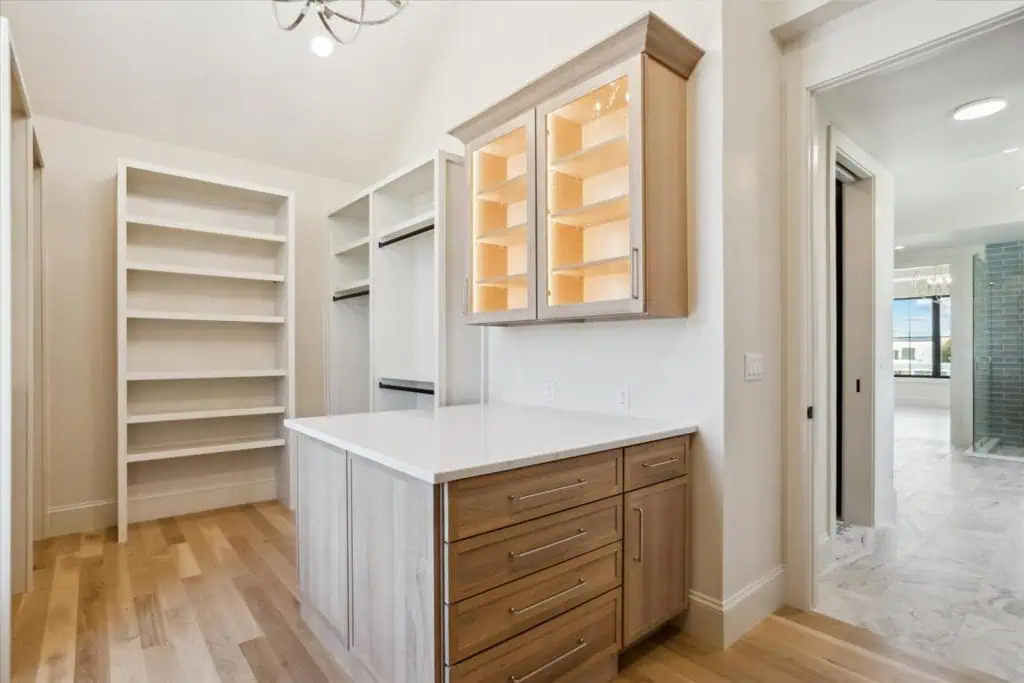 Spacious walk-in closet with wooden shelves and drawers.