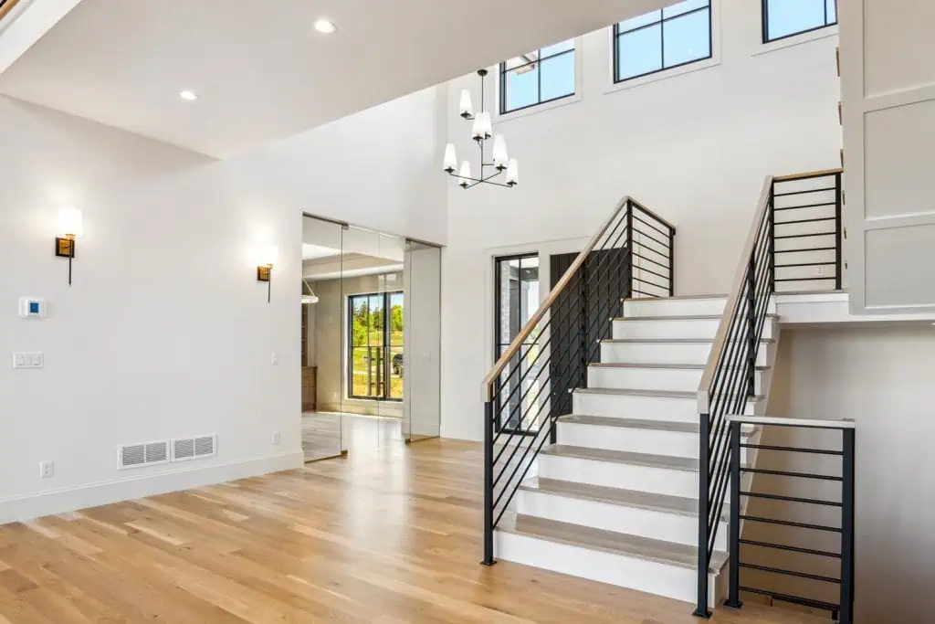 Modern home interior with staircase and glass doors.