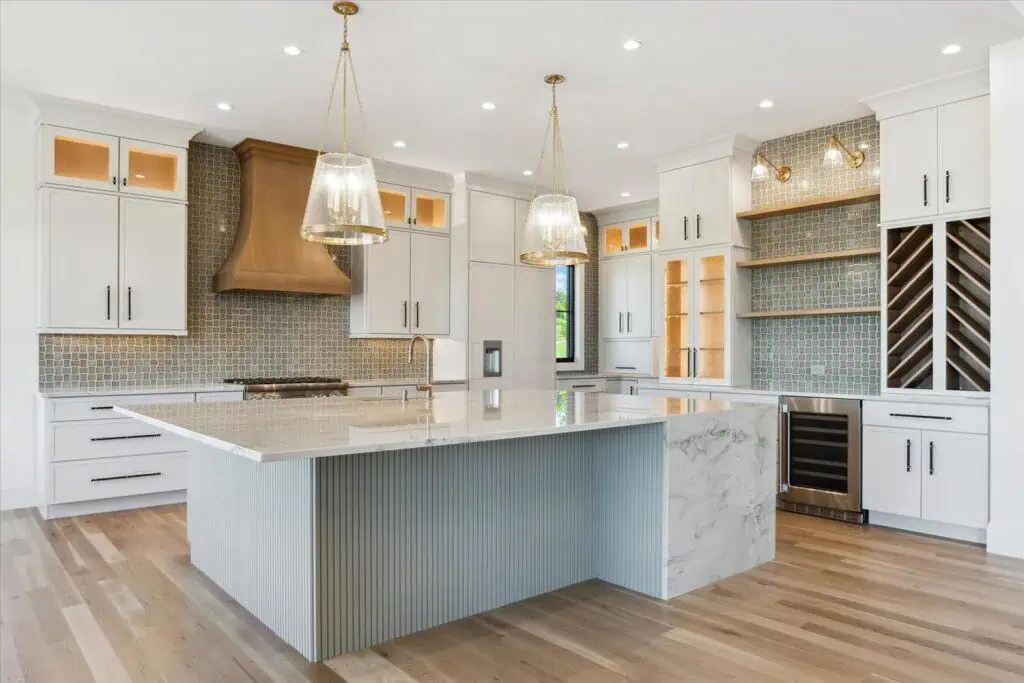 Modern kitchen with island and wine rack.