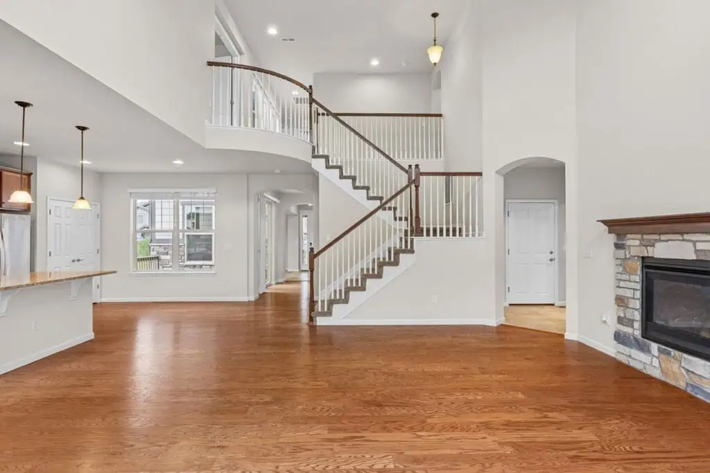 Spacious modern living room with wooden floors, staircase.