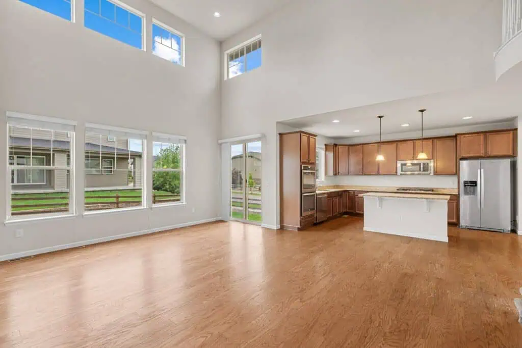Spacious kitchen with wooden floors and large windows.