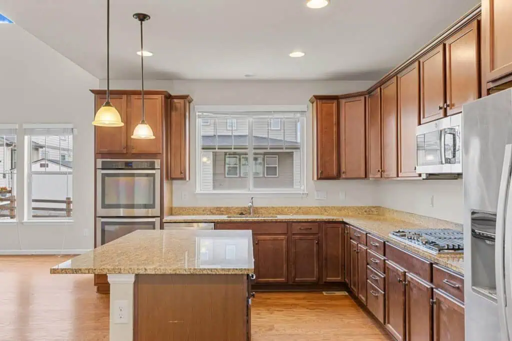Modern kitchen with wooden cabinets and granite countertops.