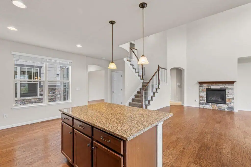 Spacious kitchen with island, stairs, fireplace.