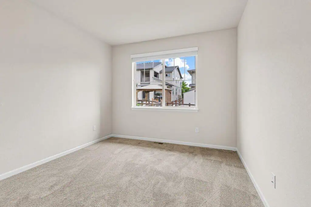 Empty room with window view of houses