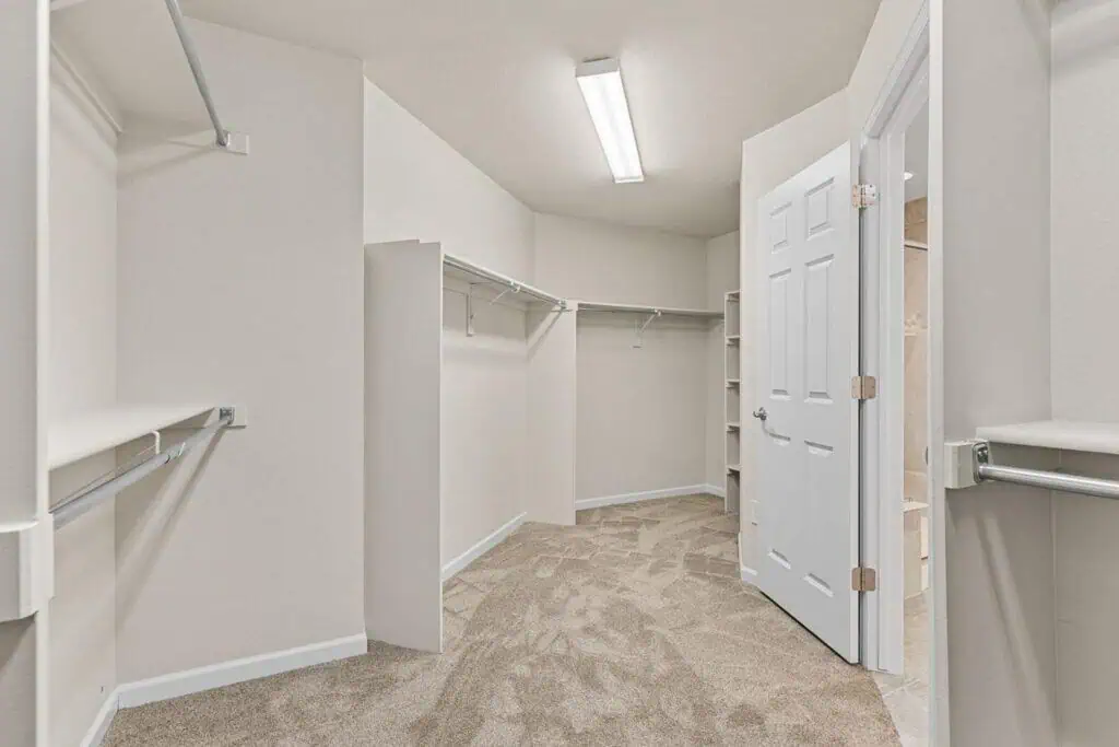 Spacious walk-in closet with empty shelves and racks.