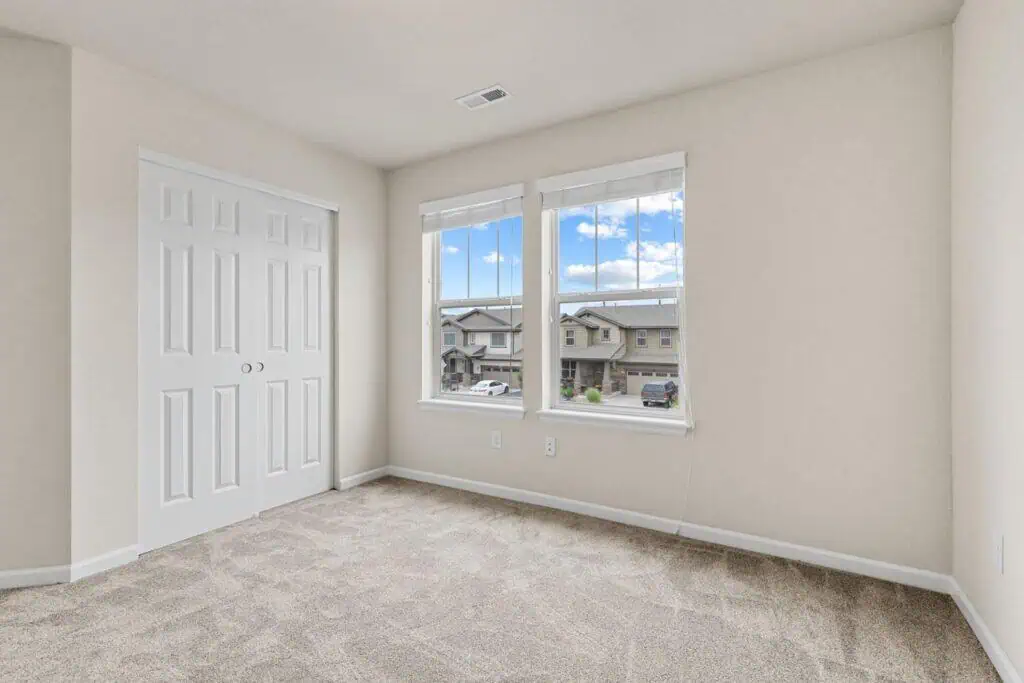 Empty room with closet and two windows