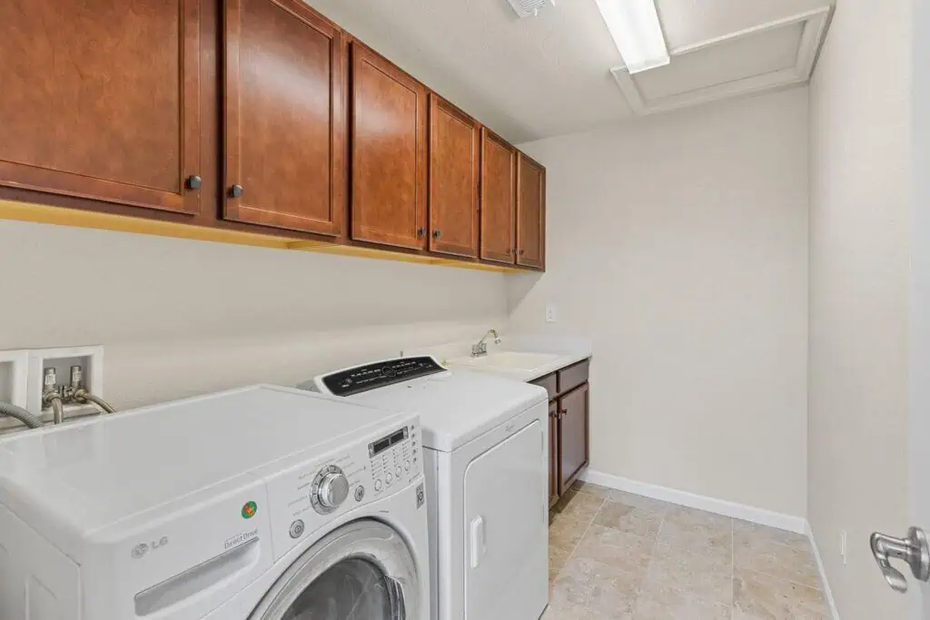 Laundry room with washer, dryer, and cabinets.