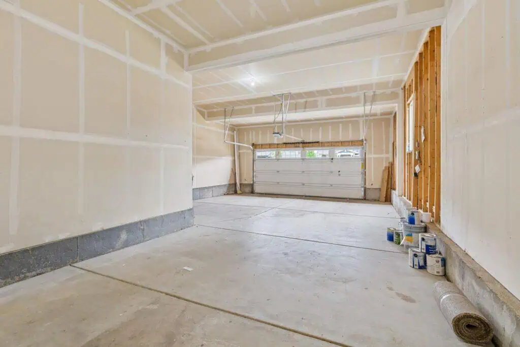 Empty garage with drywall and paint cans