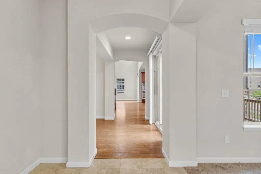 Modern hallway with wooden floors and white walls.