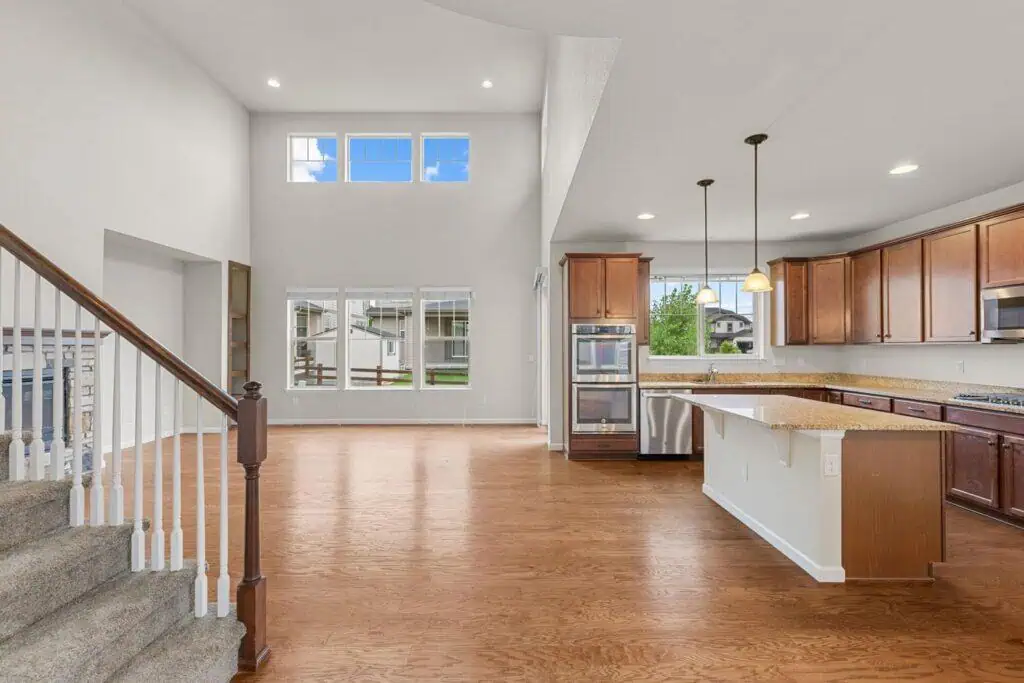 Spacious kitchen with wooden cabinets and staircase